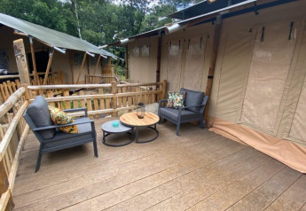 Terrasse extérieure avec sièges devant une tente safari Luxe au Camping het Horstmannsbos, Pays-Bas.