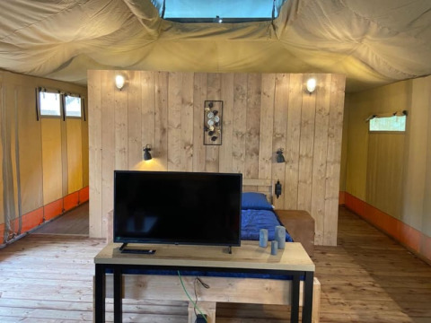 Interior view of Luxe Safari tent with private bathroom at Camping het Horstmannsbos in the Netherlands.