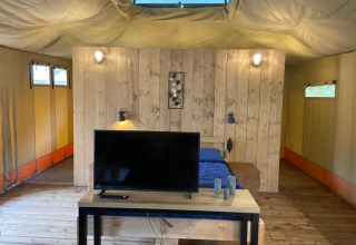 Vista interior de tienda safari de lujo con baño privado en Camping het Horstmannsbos en Países Bajos.