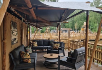 Zona de estar al aire libre en una tienda safari con muebles modernos en Camping het Horstmannsbos, Países Bajos.