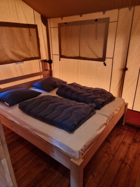 Cozy bedroom with double bed inside Safari tent + sanitary- Karper at Camping het Horstmannsbos, Netherlands.
