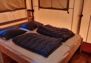Dormitorio acogedor con cama doble en la tienda Safari tent + sanitary- Karper de Camping het Horstmannsbos.