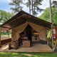 Safari telt med sanitære faciliteter, træterrasse og møbler, beliggende i skovområde på campingplads.