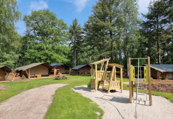 Safari tents with private bathroom at Camping het Horstmannsbos in the Netherlands, playground visible.
