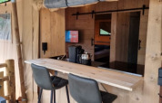 Interior view of Safari tent with private bathroom, bar area and modern chairs at Camping het Horstmannsbos, Netherlands.
