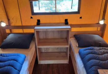 Indretning af safari telt på Camping het Horstmannsbos, Holland, med to enkeltsenge og trægulv.