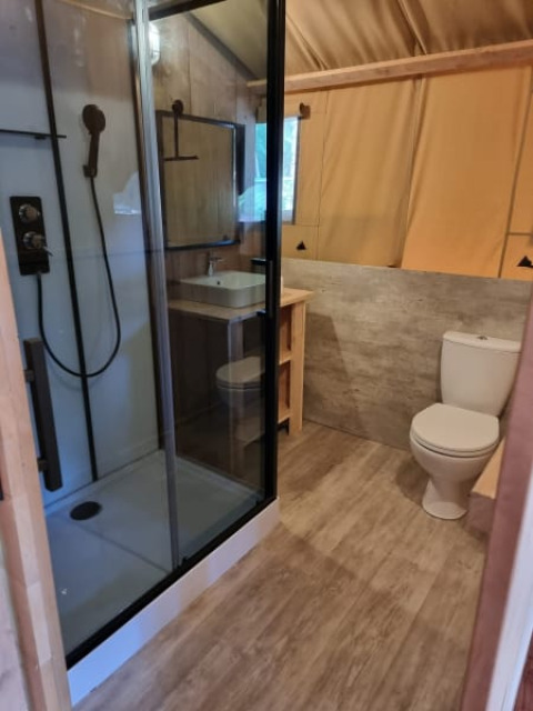 Modernes Badezimmer im Safarizelt mit Dusche, Toilette und Waschbecken auf Camping het Horstmannsbos, Niederlande.