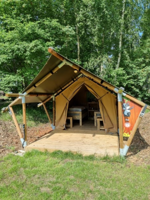 Safari tent Duolodge at Camping het Horstmannsbos in the Netherlands, nestled among lush green trees.