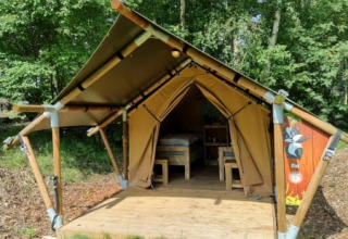 Safari tent Duolodge at Camping het Horstmannsbos in the Netherlands, nestled among lush green trees.
