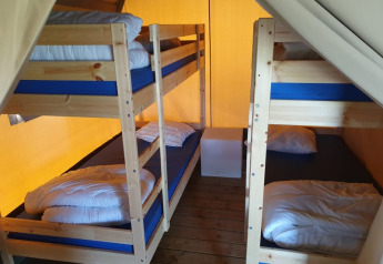 Indvendig af safaritelten på Ballum Camping i Danmark med to køjesenge og trægulv.