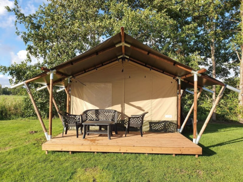 Safari-Zelt auf Camping de Oude Rijn in den Niederlanden, mit Holzterrasse und Gartenmöbeln im Freien.