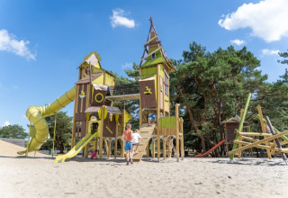 Niños juegan en un gran parque infantil con torres y toboganes en Safari tent, Camping GT Keiheuvel, Bélgica.