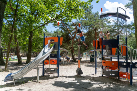 Niños juegan en un parque infantil moderno con tobogán y estructuras para trepar en Camping GT Keiheuvel, Bélgica.