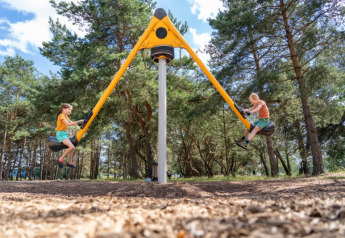 Due bambini giocano su un'altalena moderna vicino alla tenda safari del Camping GT Keiheuvel, Belgio.