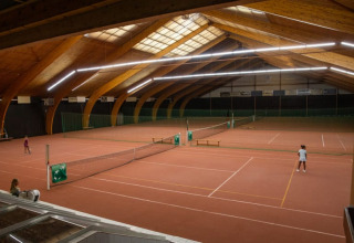 Indendørs tennisbane i trætelt-stil ved Safari telt på Camping GT Keiheuvel, Belgien, med spillere.