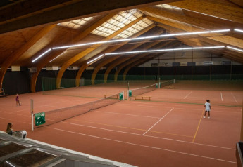 Campo da tennis coperto in stile tenda safari al Camping GT Keiheuvel in Belgio, con giocatori sul campo.