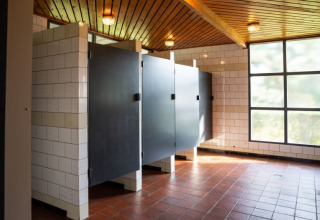Bagno pubblico moderno con porte nere e piastrelle bianche nel Safari tent al Camping GT Keiheuvel, Belgio.