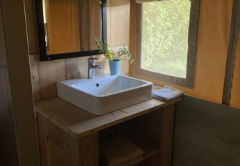 Lavabo con specchio e asciugamani in una tenda safari con servizi igienici al Tolne Camping in Danimarca.