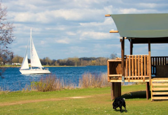 Safari-telt med sanitære faciliteter ved Recreatiepark Riverside i Holland, udsigt over sø og sejlbåd.