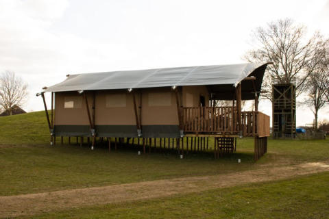 Tenda safari con servizi igienici su palafitte al Recreatiepark Riverside nei Paesi Bassi, su prato verde.