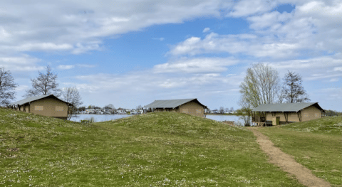Udsigt over safari-telte med egen badeværelse på Recreatiepark Riverside i Holland nær søen.
