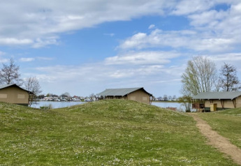 Tentes safari avec sanitaires privés au Recreatiepark Riverside, Pays-Bas, face au lac paisible.