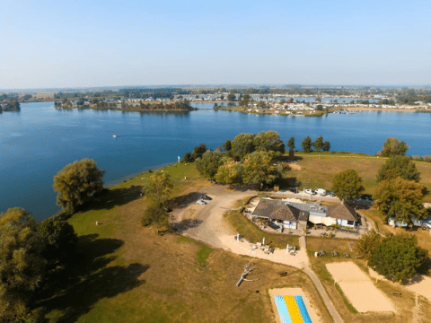 Vista aerea della tenda safari con servizi igienici privati al Recreatiepark Riverside vicino al lago.