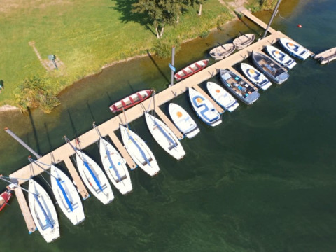 Luchtfoto van boten aan een steiger bij Recreatiepark Riverside, Nederland, dicht bij safaritent met sanitair.