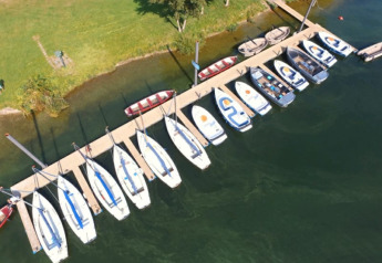 Vue aérienne de bateaux amarrés à une jetée au Recreatiepark Riverside, Pays-Bas, près d'une tente safari avec sanitaires.
