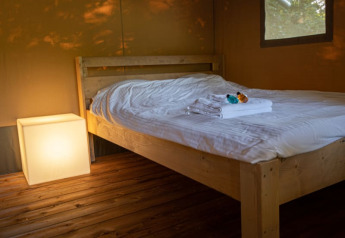 Indretning af seng i Safari telt på Vakantiepark de Toffe Peer, Holland, med oplyst terningelys.