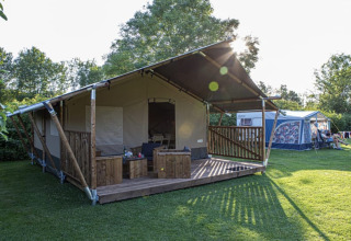Safari-Zelt im Vakantiepark de Toffe Peer in den Niederlanden mit Holzterrasse und Gartenmöbeln.