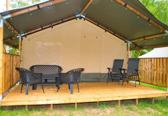 Tenda safari con terrazza in legno e mobili da esterno al Camping Aller-Leine-Tal in Germania.