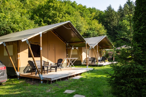 Safari-Zelte mit Holzterrassen auf dem Campingplatz Bockenauer Schweiz in Deutschland, umgeben von viel Grün.