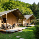Safari-telte med træterrasser på Camping Bockenauer Schweiz i Tyskland, omgivet af grønne træer om sommeren.