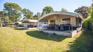 Outdoor photo of Tentvilla safari tents at Holiday park Ackersate in the Netherlands on a sunny day.