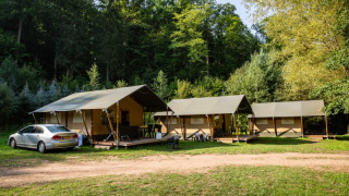Tienda safari con instalaciones sanitarias en Camping Bockenauer Schweiz, Alemania, junto a bosques verdes.
