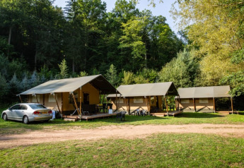 Tienda safari con instalaciones sanitarias en Camping Bockenauer Schweiz, Alemania, junto a bosques verdes.