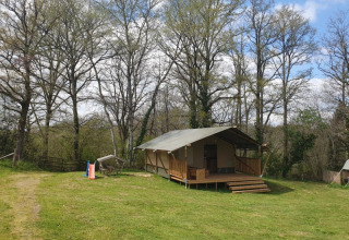 Safaritent bij Moulin du Pommier Glamping & Camping in Frankrijk, omringd door bomen en natuur.