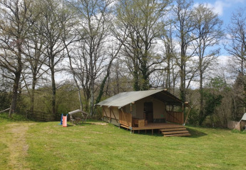 Safari-Zelt im Moulin du Pommier Glamping & Camping in Frankreich, umgeben von grüner Natur.