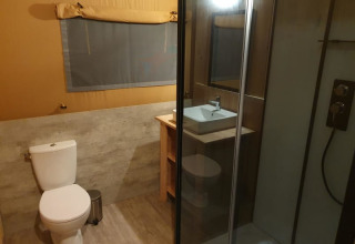 Bagno in tenda safari con WC, doccia e lavabo al Moulin du Pommier Glamping & Camping in Francia.