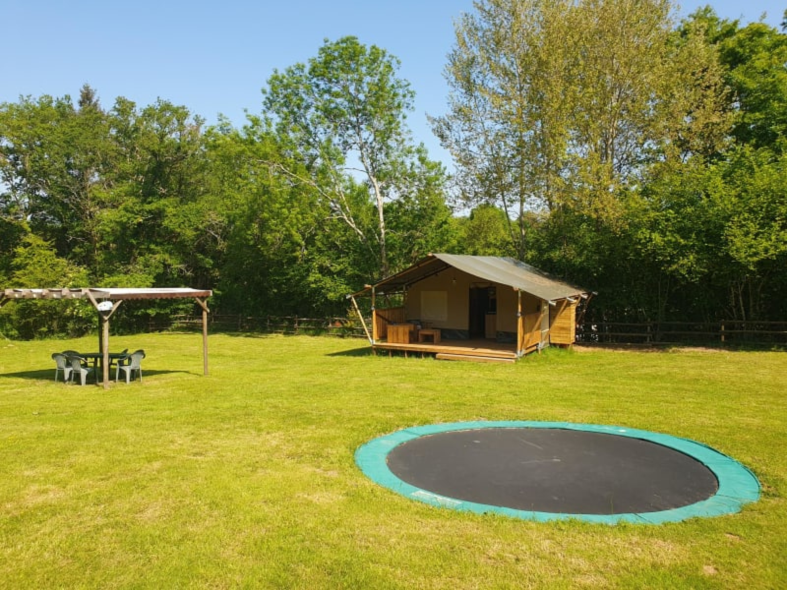 Safaritent met privéterras, trampoline en zitgedeelte bij Moulin du Pommier Glamping, Frankrijk.