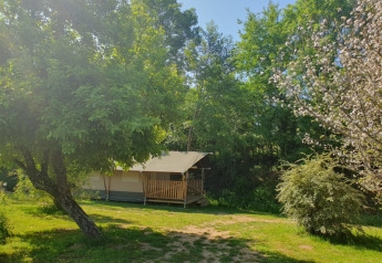 Tienda safari con baño privado en Moulin du Pommier Glamping & Camping, rodeada de árboles en Francia.