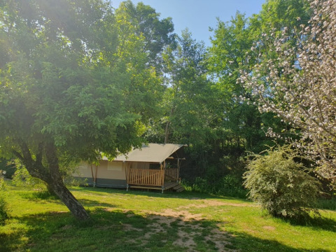 Tienda safari con baño privado en Moulin du Pommier Glamping & Camping, rodeada de árboles en Francia.
