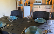 Comedor y cocina en tienda safari en Camping Sonnenberg, Alemania, mesa puesta para cuatro personas.