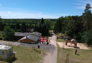 Luftaufnahme des Safari-Zelts auf dem Campingplatz Sonnenberg in Deutschland mit Spielplatz und Wald.