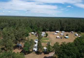 Vista aerea della tenda safari al Camping Sonnenberg in Germania, circondata da boschi e roulotte.