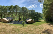 Tenda safari con servizi igienici a Casa & Glamping Sorriso, Italia, immersa tra pini e natura verde.