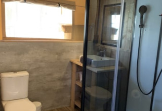 Modern bathroom inside safari tent at Casa & Glamping Sorriso, Italy, featuring shower and toilet.