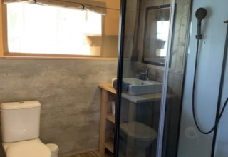 Salle de bain moderne dans une tente safari à Casa & Glamping Sorriso, Italie, avec douche et toilettes.