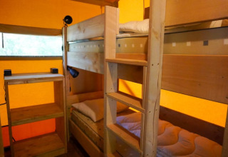 Indvendig udsigt af Safari telt med køjesenge og hylder på Camping Pittoresque i Frankrig.